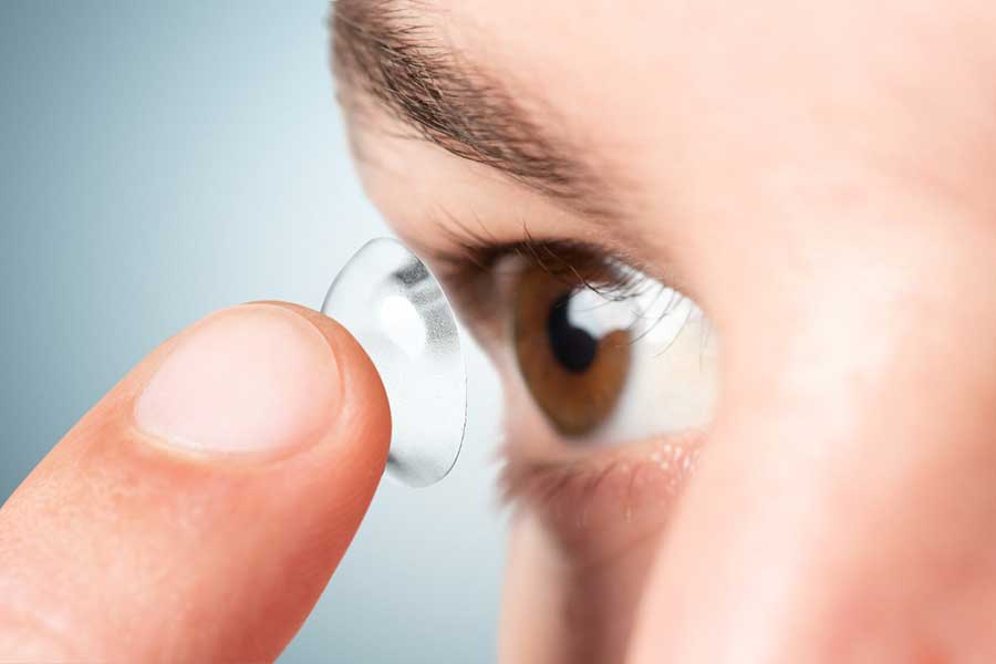 imagem de pessoa colocando uma lente de contato no olho